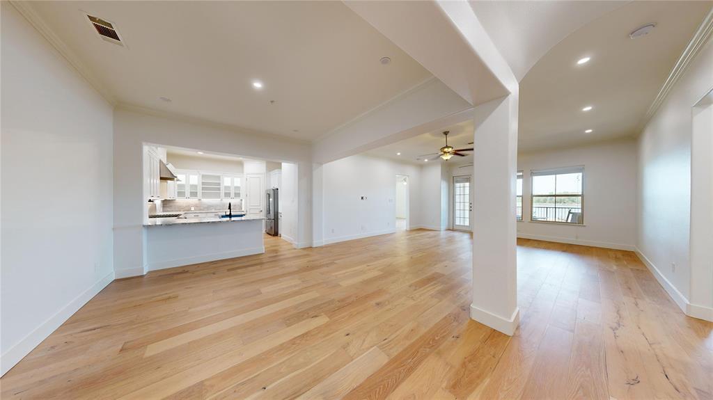 a view of an empty room and a kitchen