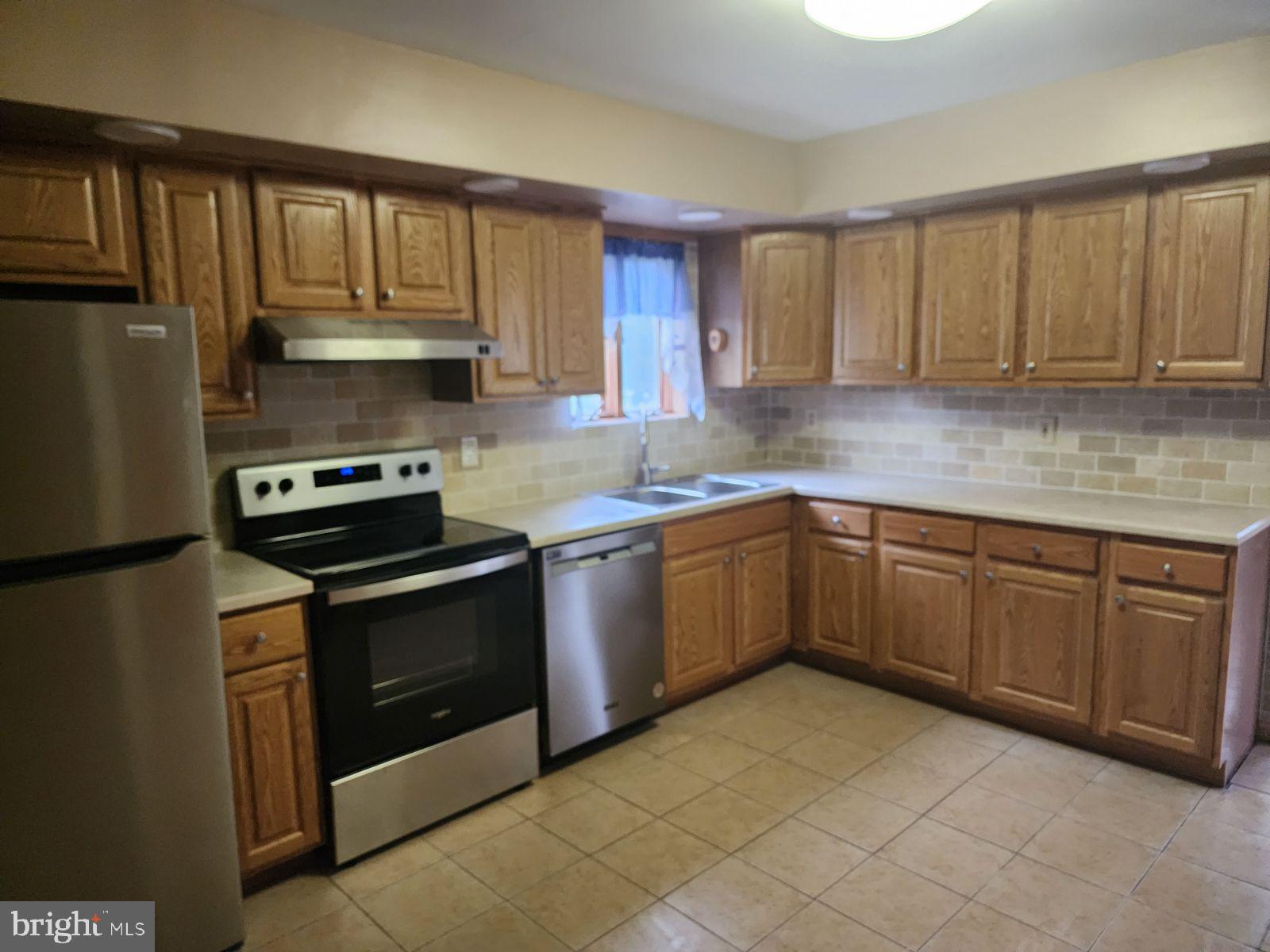 a kitchen with stainless steel appliances granite countertop a stove a sink dishwasher and a refrigerator