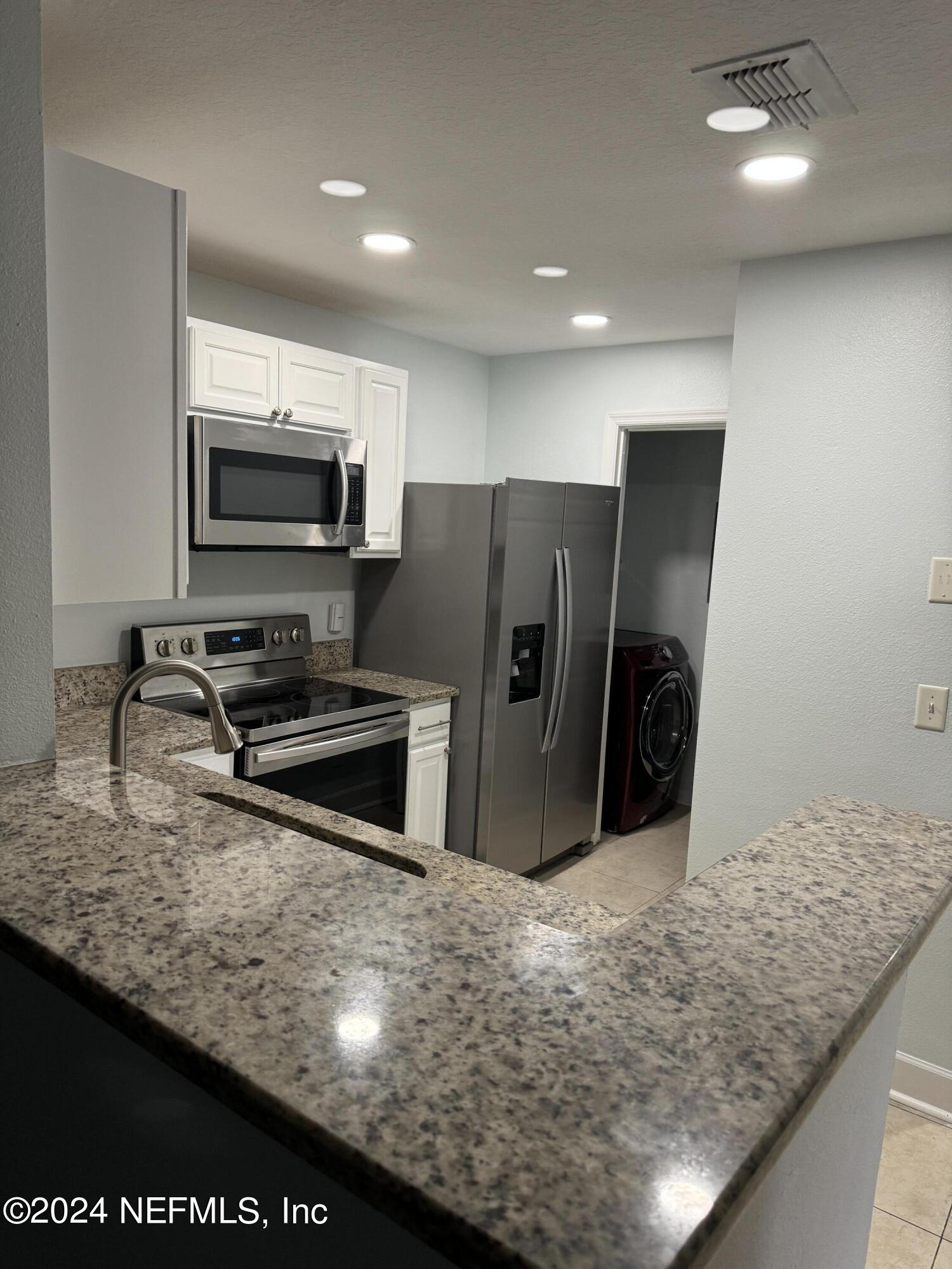 a kitchen with stainless steel appliances granite countertop a refrigerator and a sink