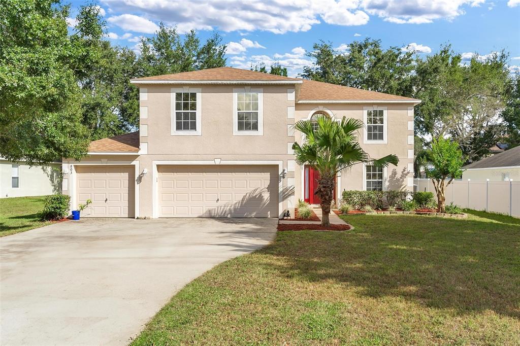 a view of a house with a yard and garage