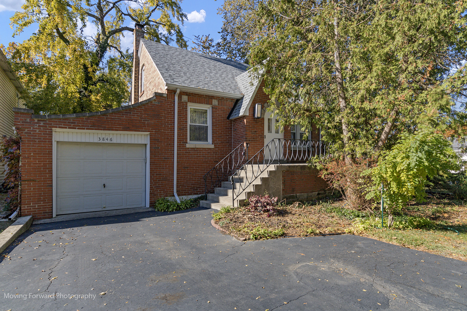 a brick house with trees in front of it