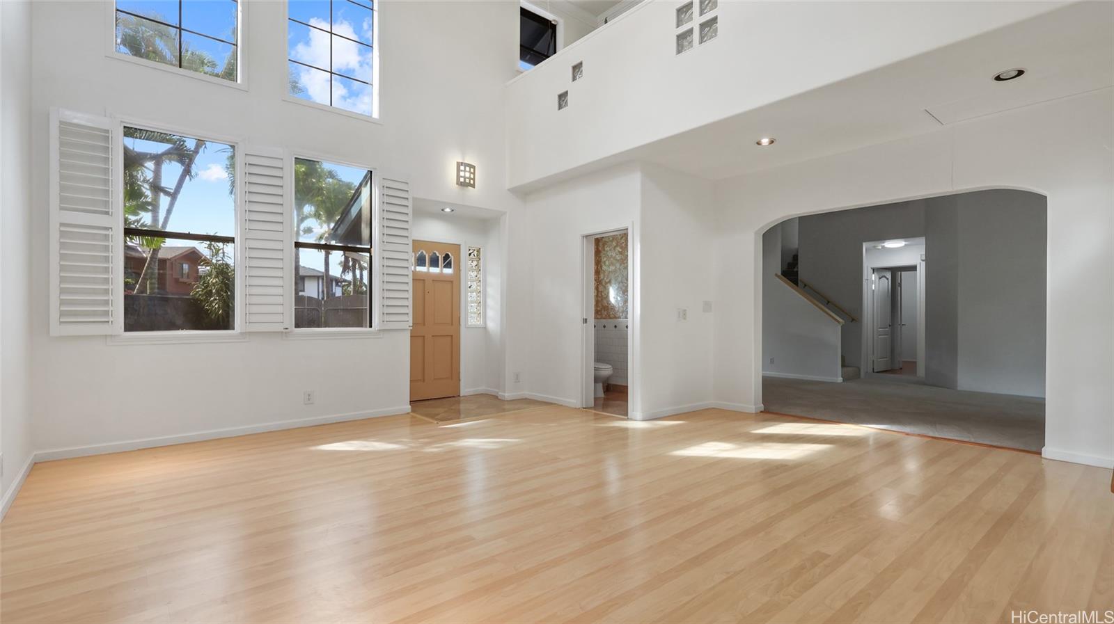 a view of a big room with wooden floor and windows