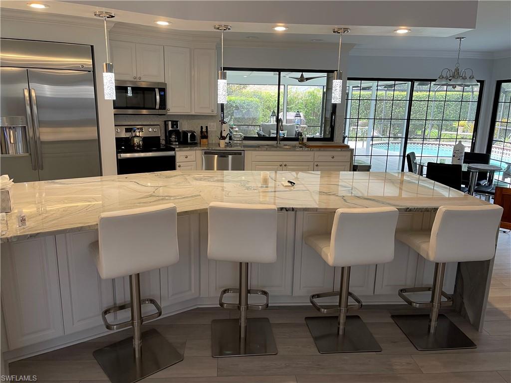 a large kitchen with a table chairs refrigerator and cabinets