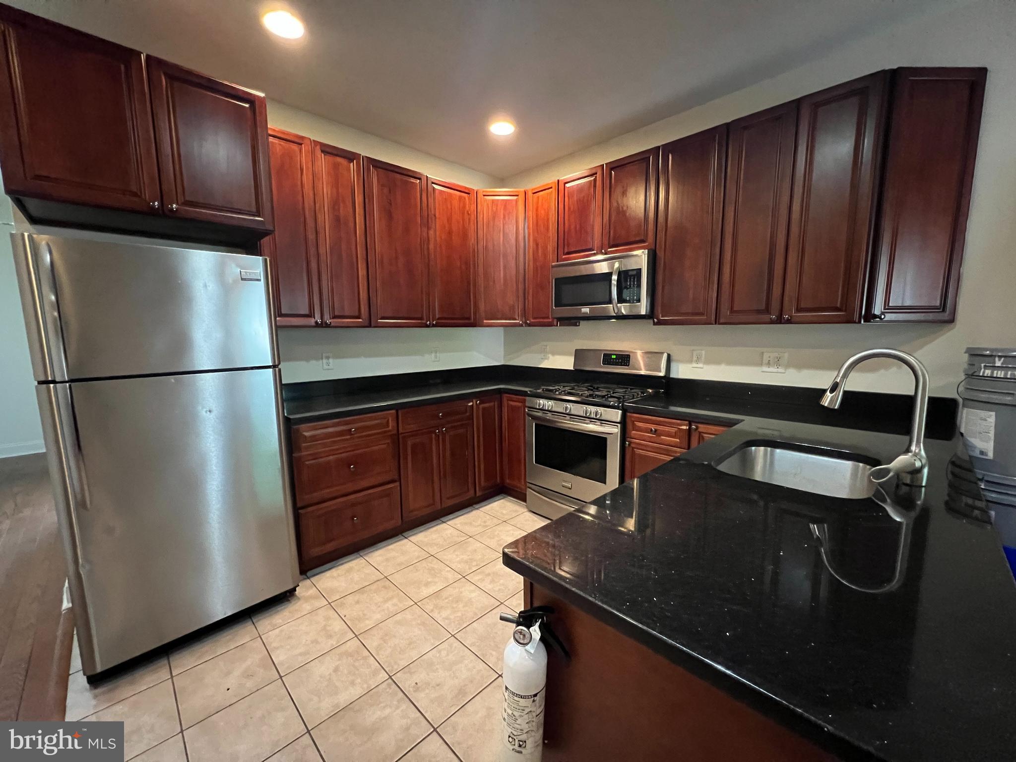 a kitchen with a sink a refrigerator and cabinets