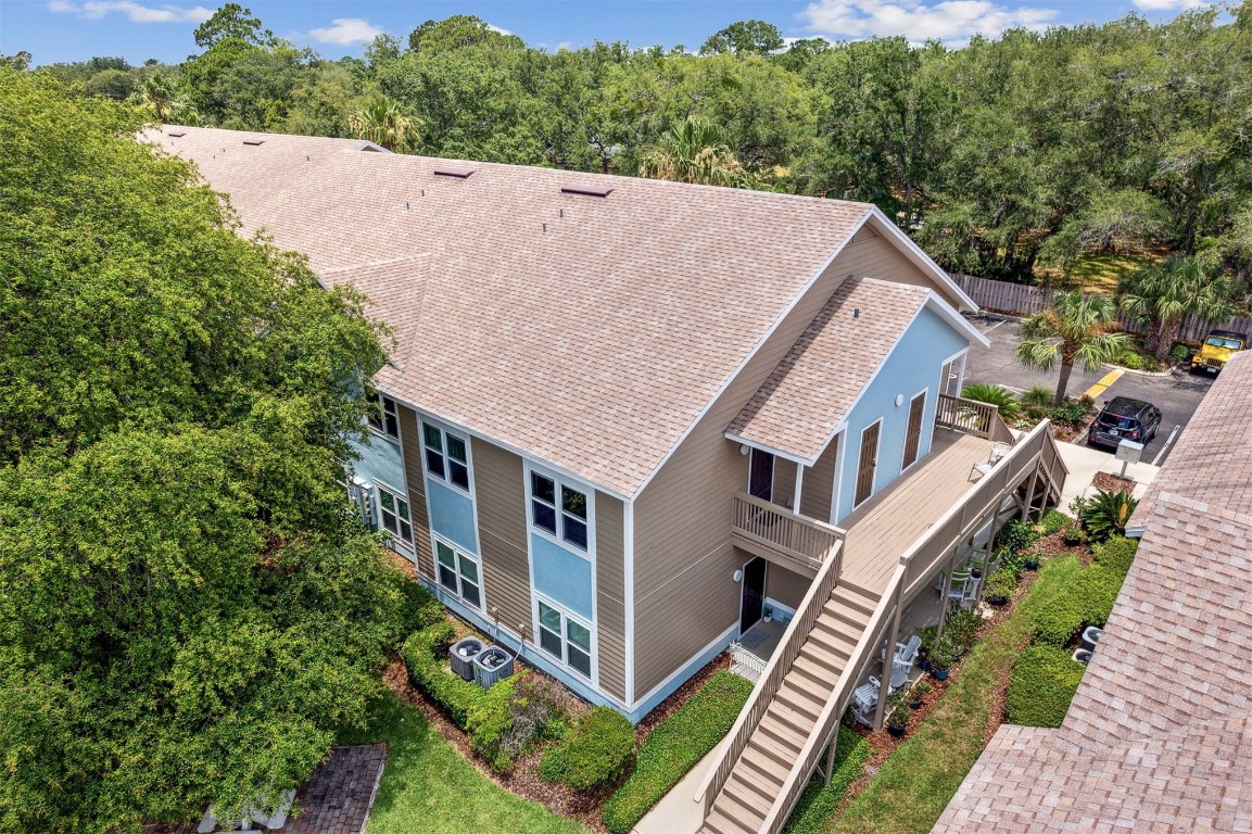 an aerial view of house with yard and trees in the background