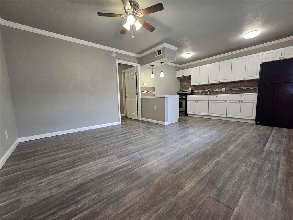 a view of a kitchen with wooden floor and a refrigerator