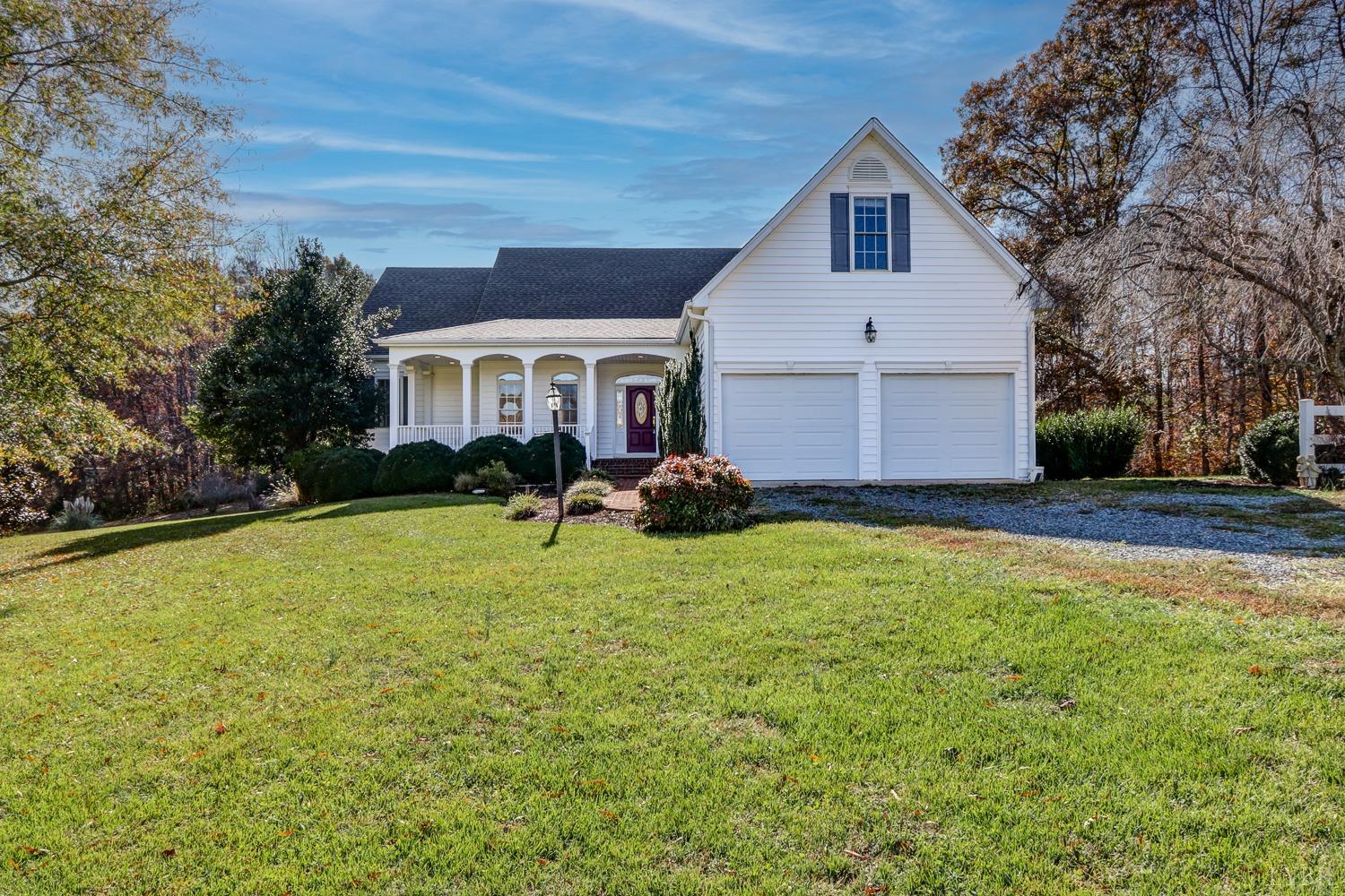 a front view of house with yard and trees in the background