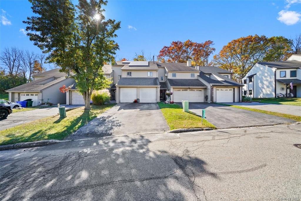 a view of a house with a big yard and large trees