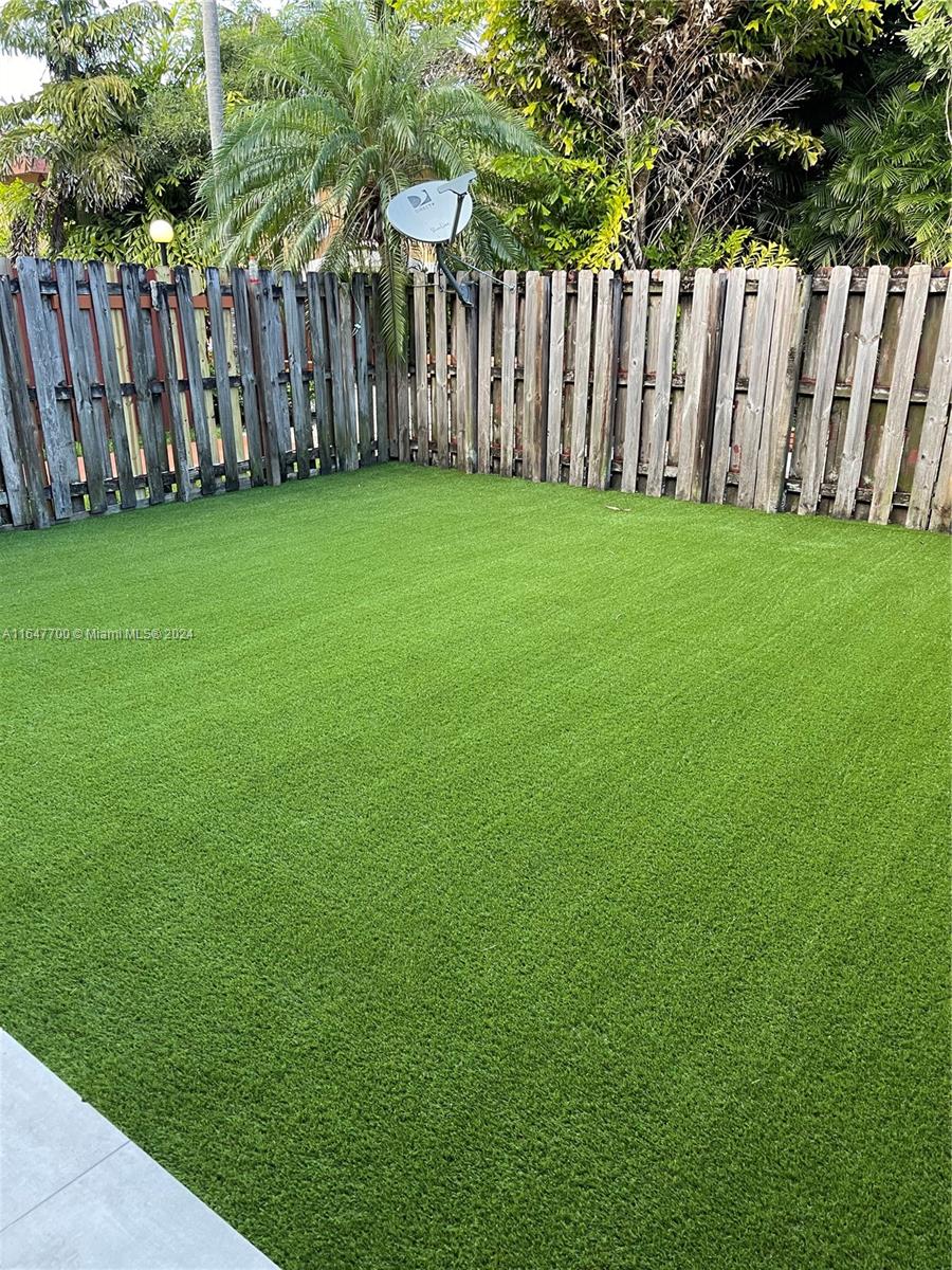 a view of a yard with wooden fence