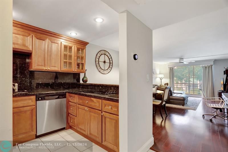 a kitchen with granite countertop a stove a sink a dining table and chairs