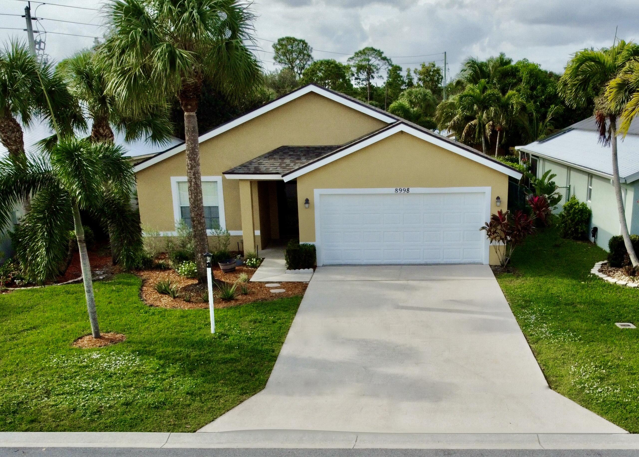 front view of house with a yard and potted plants