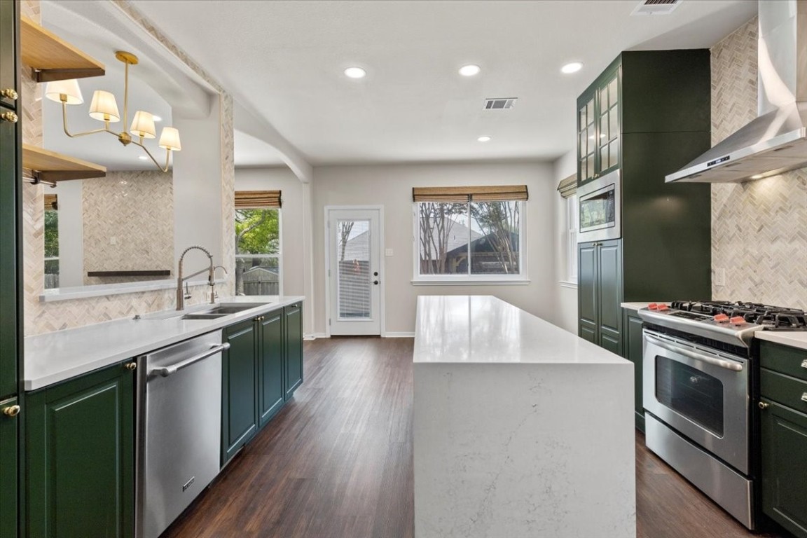 a kitchen with stainless steel appliances granite countertop a sink stove and refrigerator