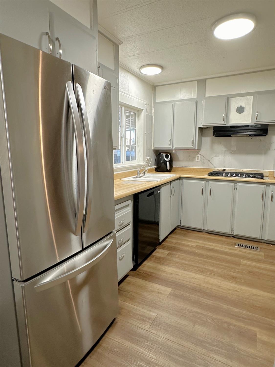 a kitchen with stainless steel appliances granite countertop a refrigerator sink and stove