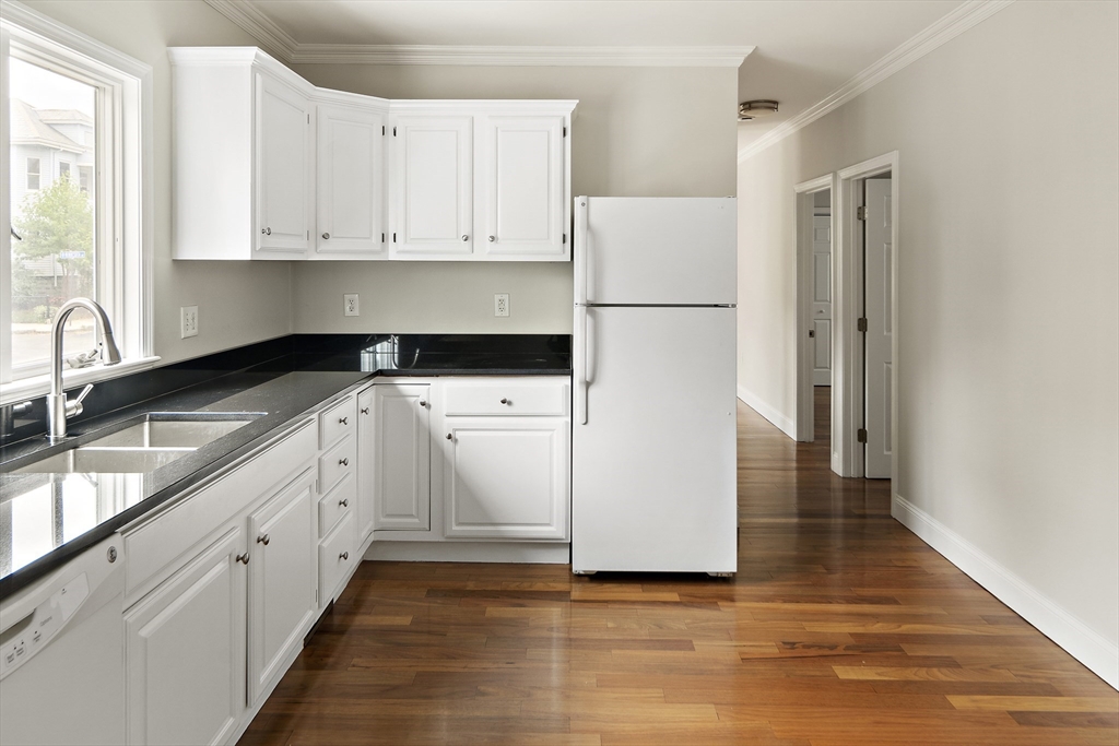 a kitchen with granite countertop white cabinets and white appliances