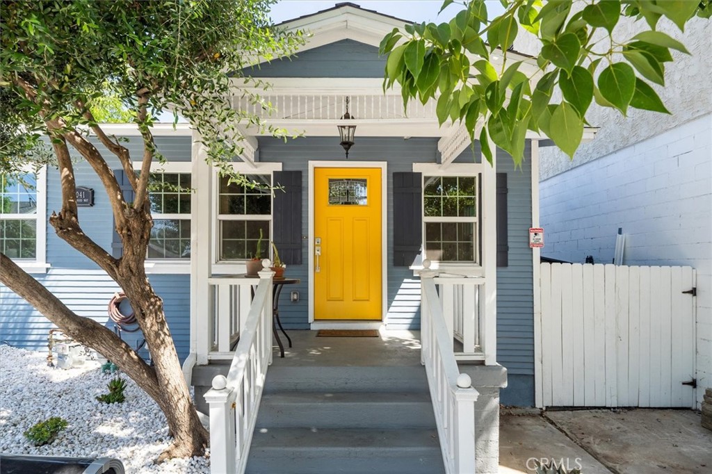 a front view of a house with a tree