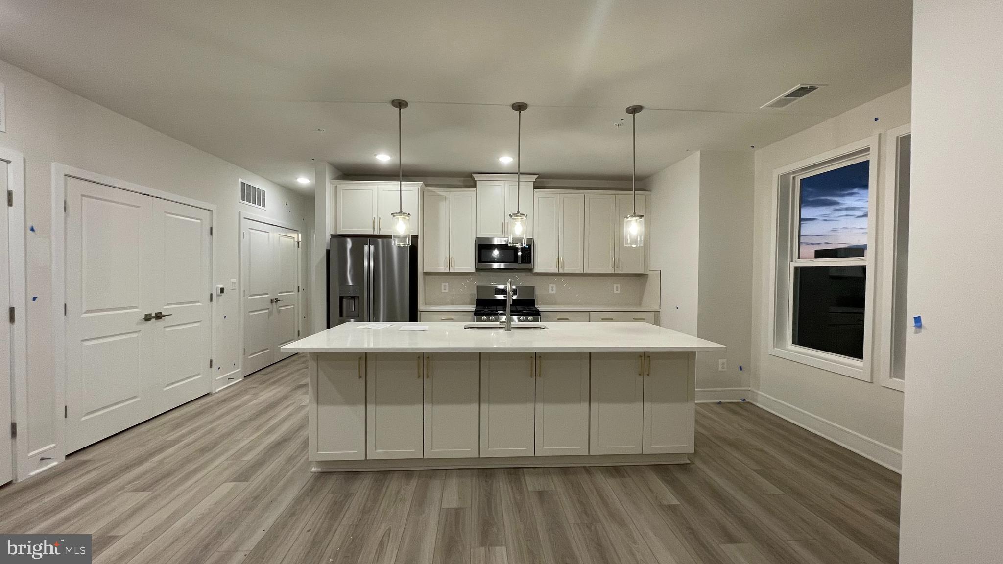 a view of a kitchen with a sink stainless steel appliances and cabinets