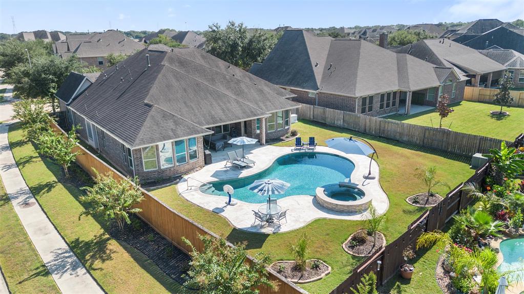 an aerial view of a house with swimming pool and outdoor seating