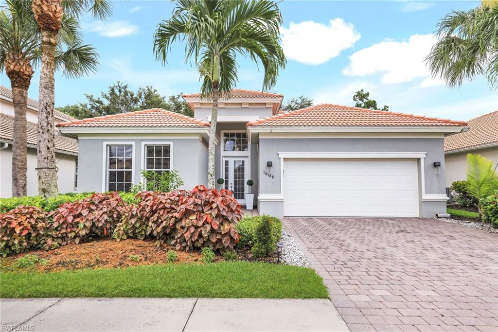 front view of a house with a yard and palm trees