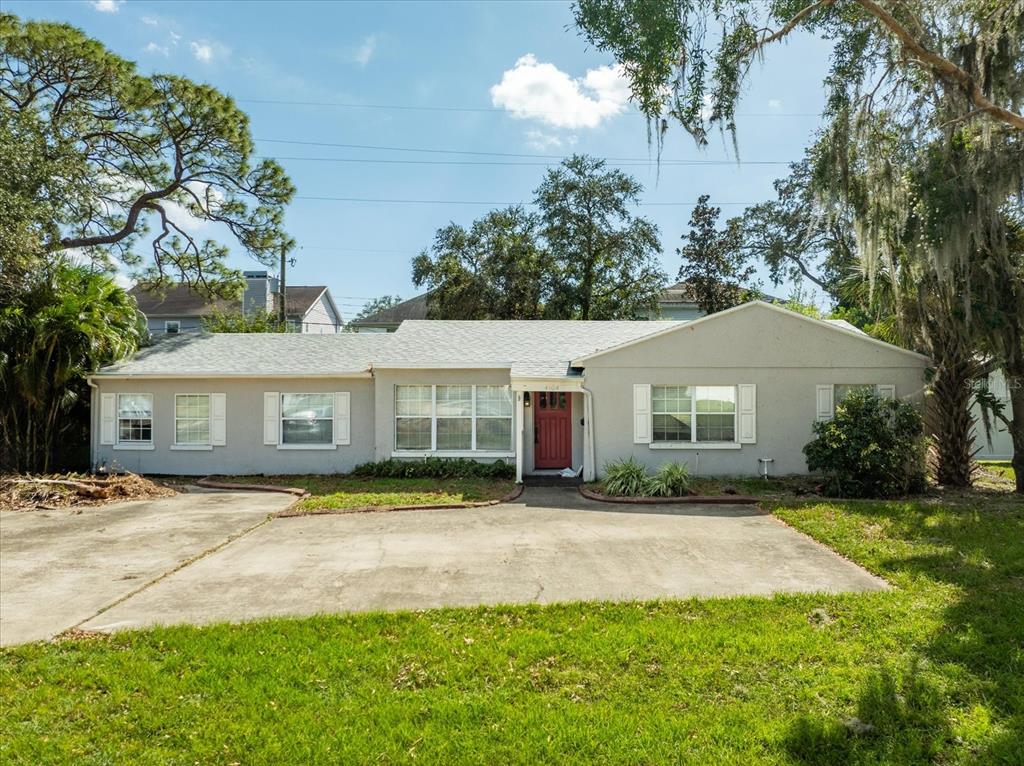 a front view of a house with a yard and trees