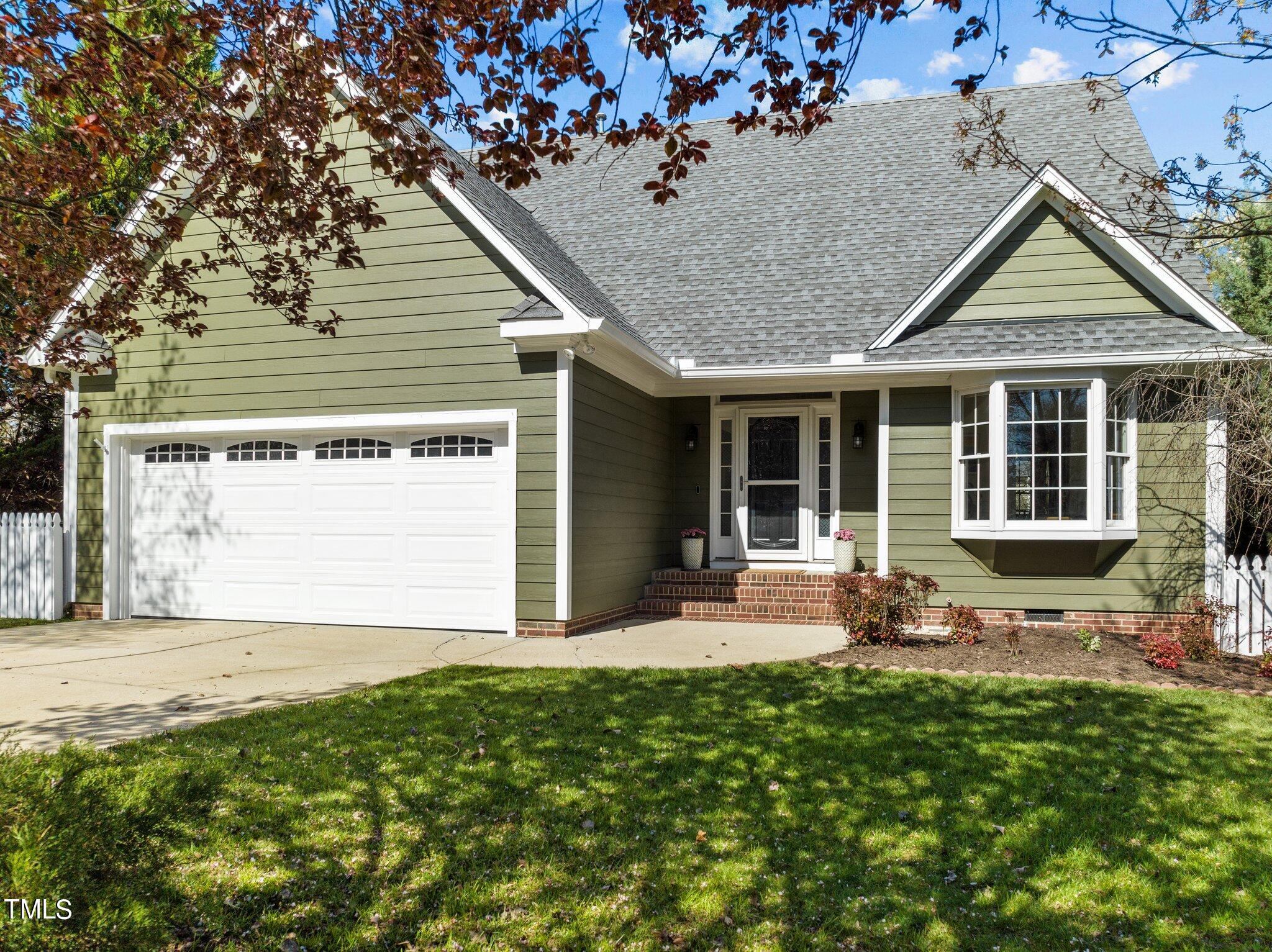 a front view of a house with a garden and plants