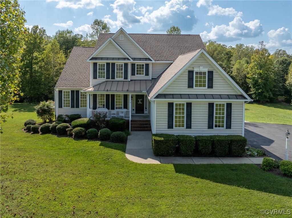 View of front facade with a porch and a front lawn