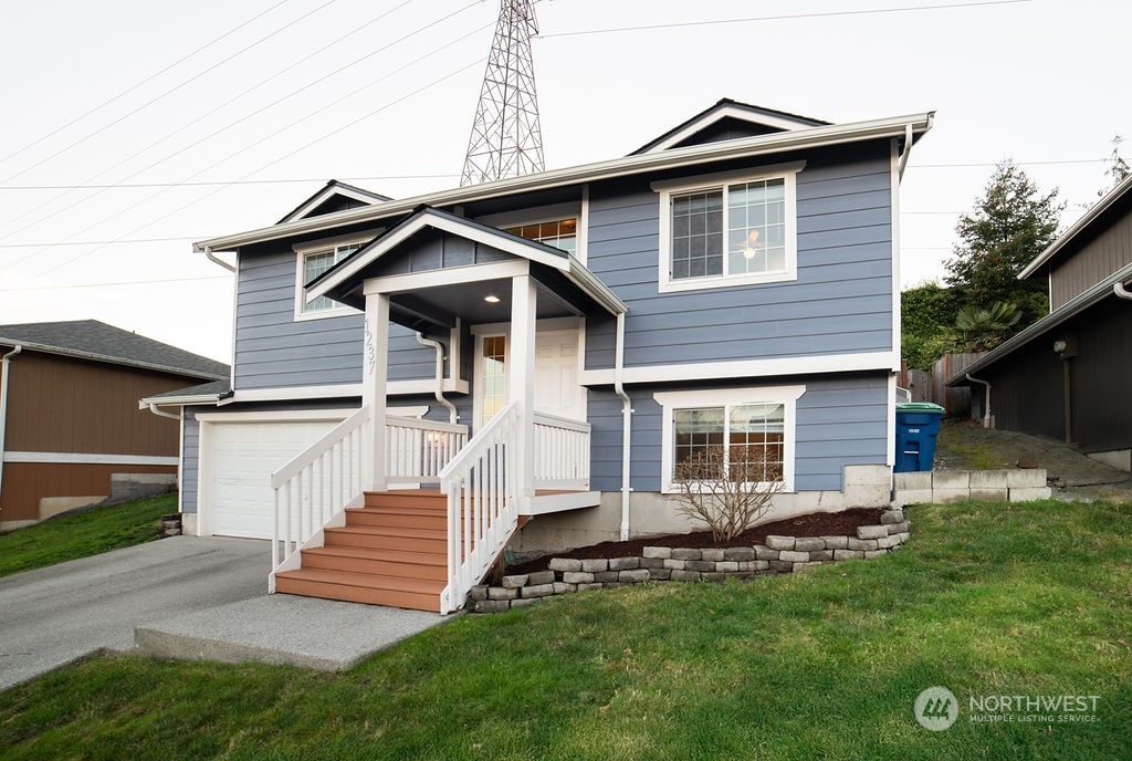 a view of a house with a yard and stairs