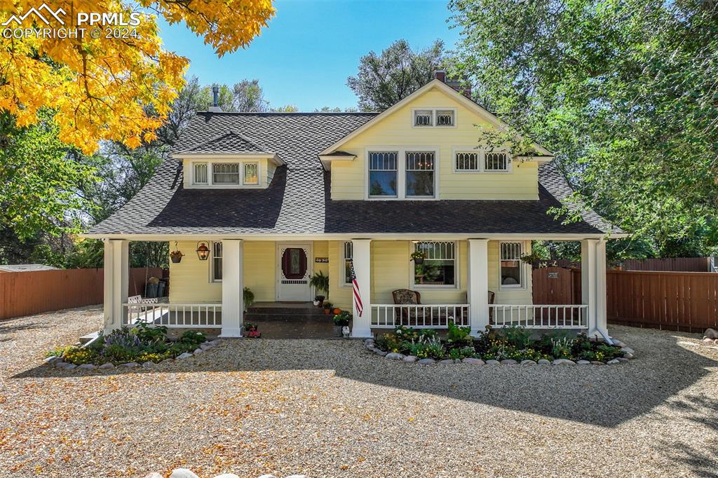 a front view of a house with a yard and potted plants