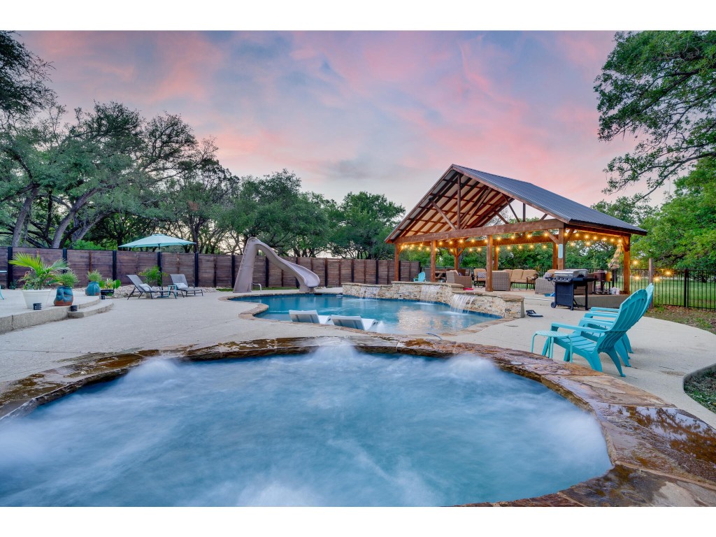 a swimming pool with outdoor seating and yard in the back