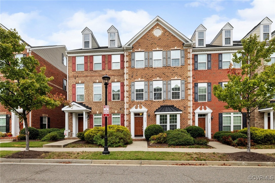 front view of a brick house next to a yard