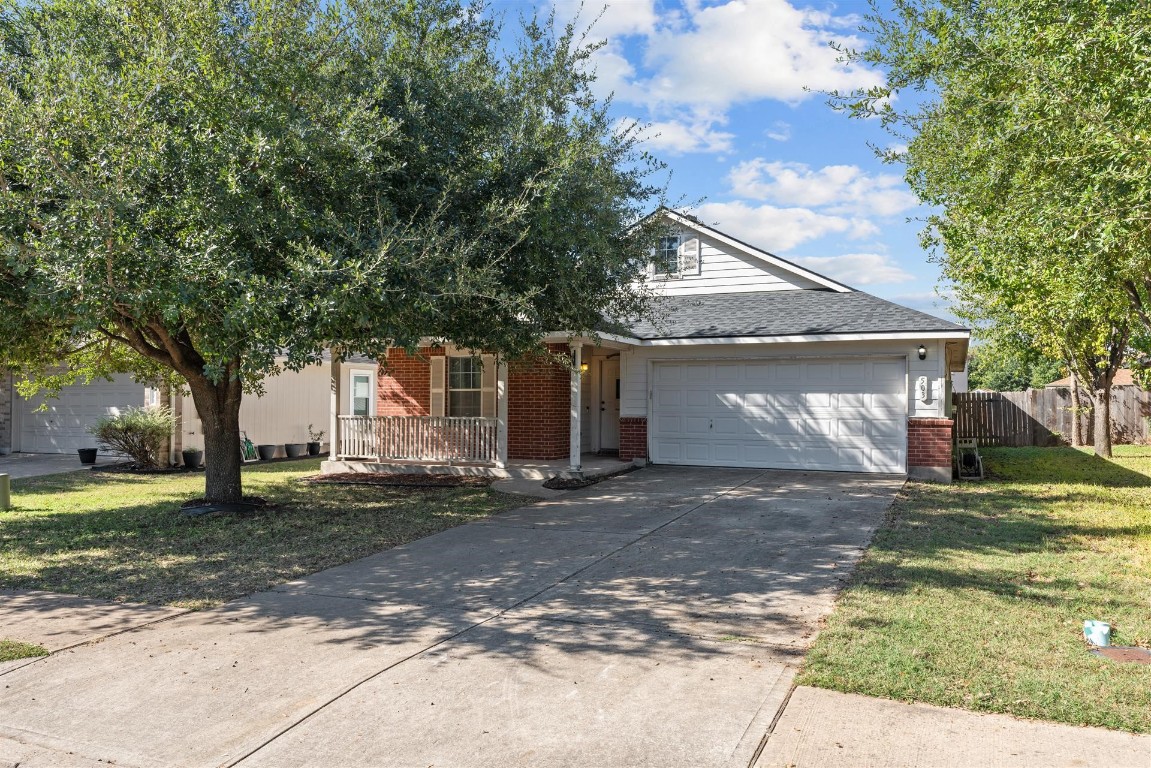 a view of a house with a yard and large tree