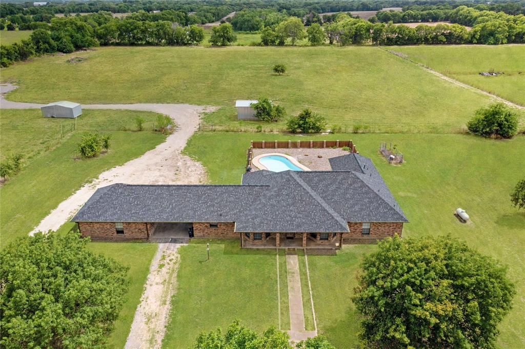 an aerial view of a house with a garden and lake view