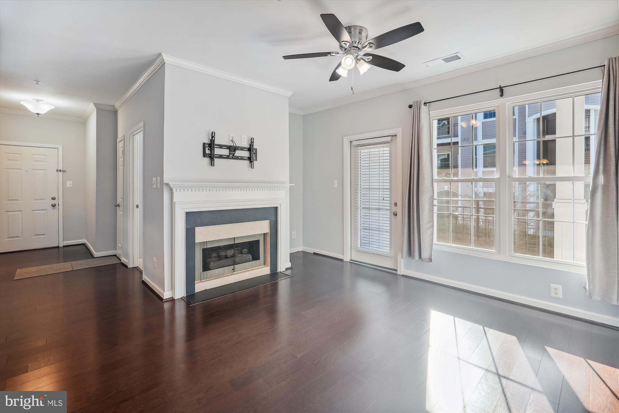 a living room with wooden floor and a fireplace