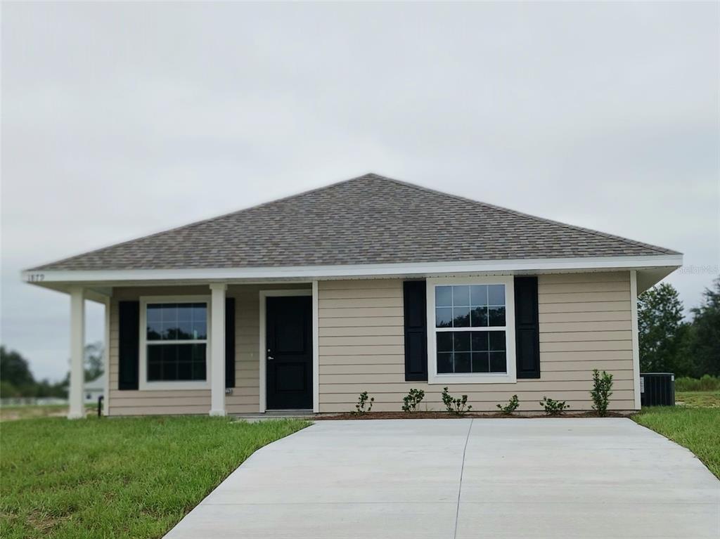 a front view of a house with a garden and yard