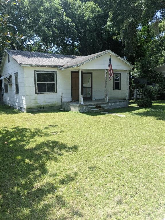 a view of a house with a yard and a table and chairs