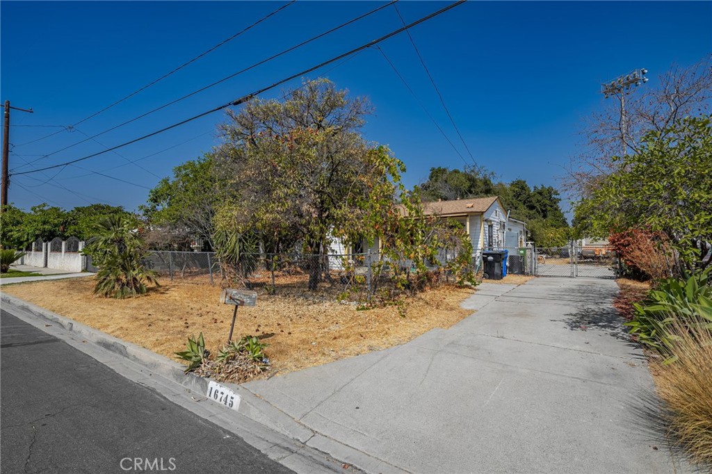 a view of a house with small yard and tree s