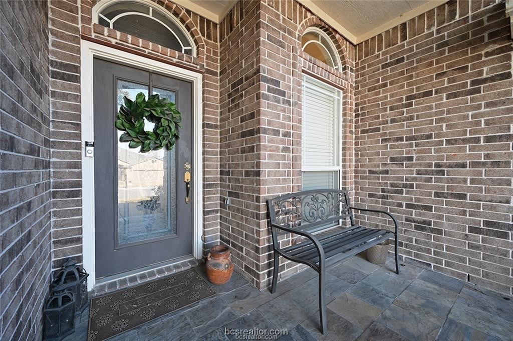 a view of a balcony with furniture and floor to ceiling window