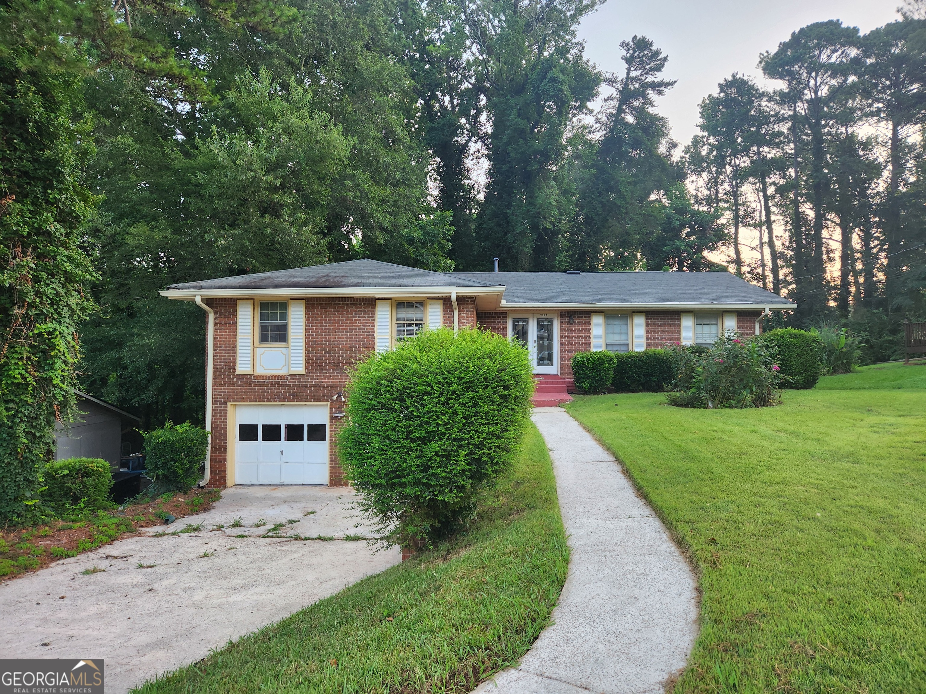 a front view of a house with a yard and trees