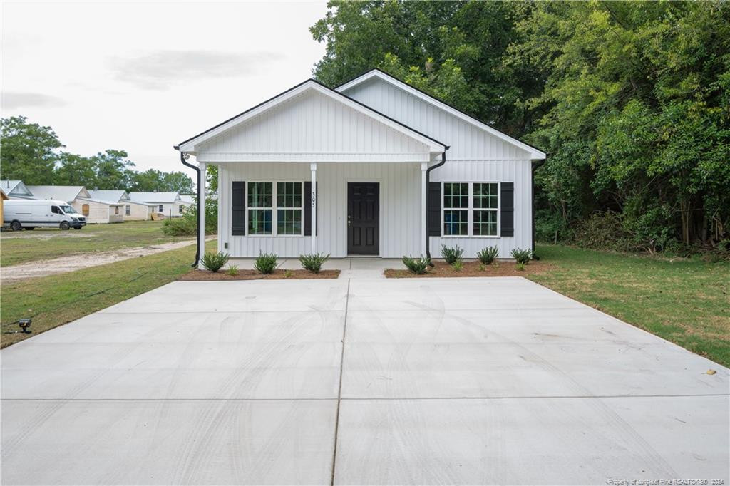 a front view of a house with a yard and trees