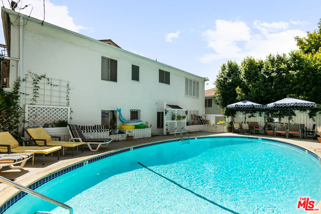 a view of a house with swimming pool and sitting area