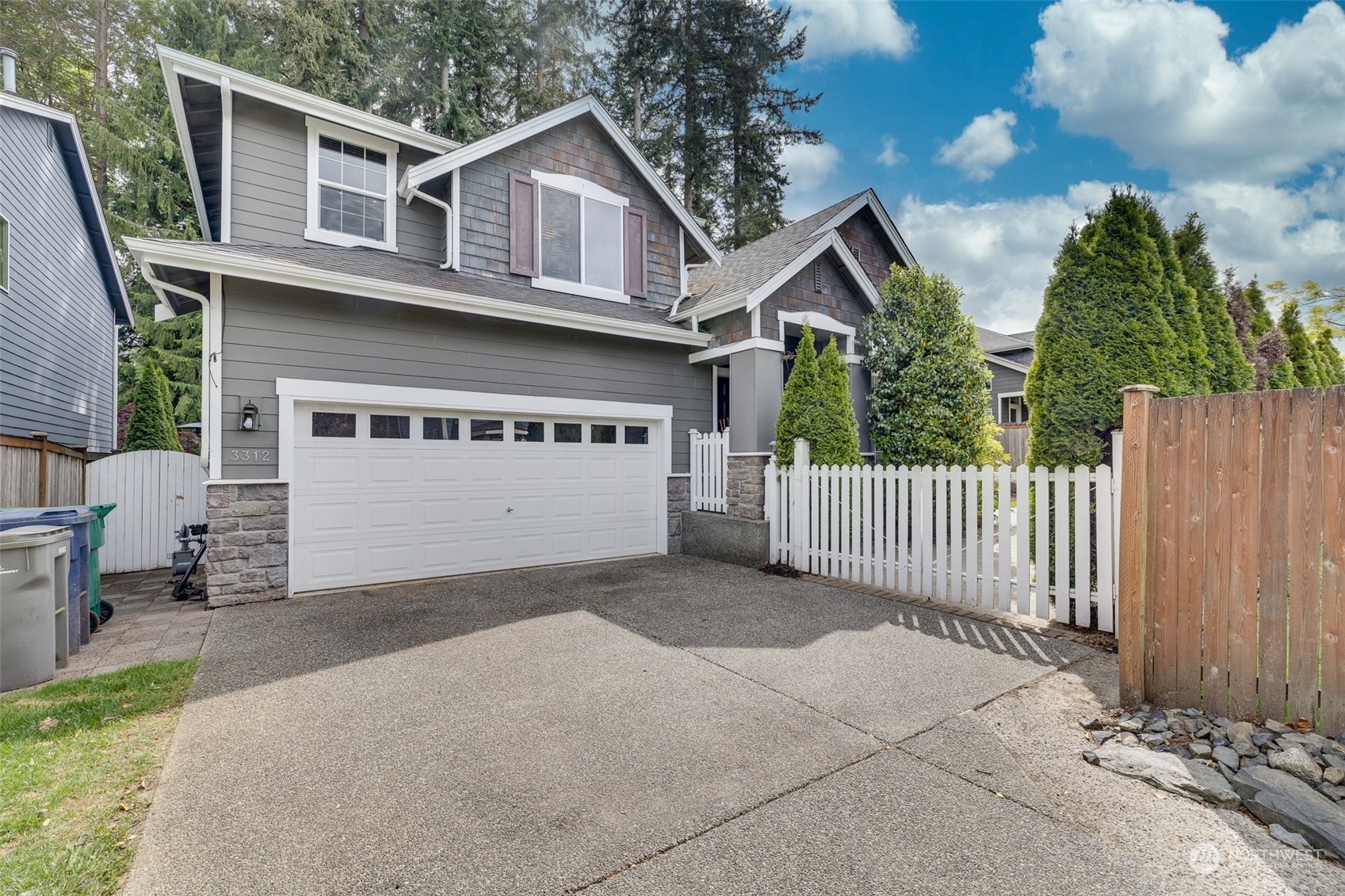 a view of a house with wooden fence next to a yard