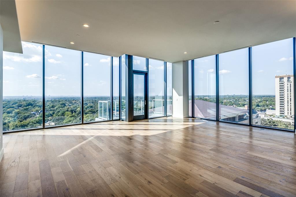 a view of an empty room with wooden floor and a floor to ceiling window