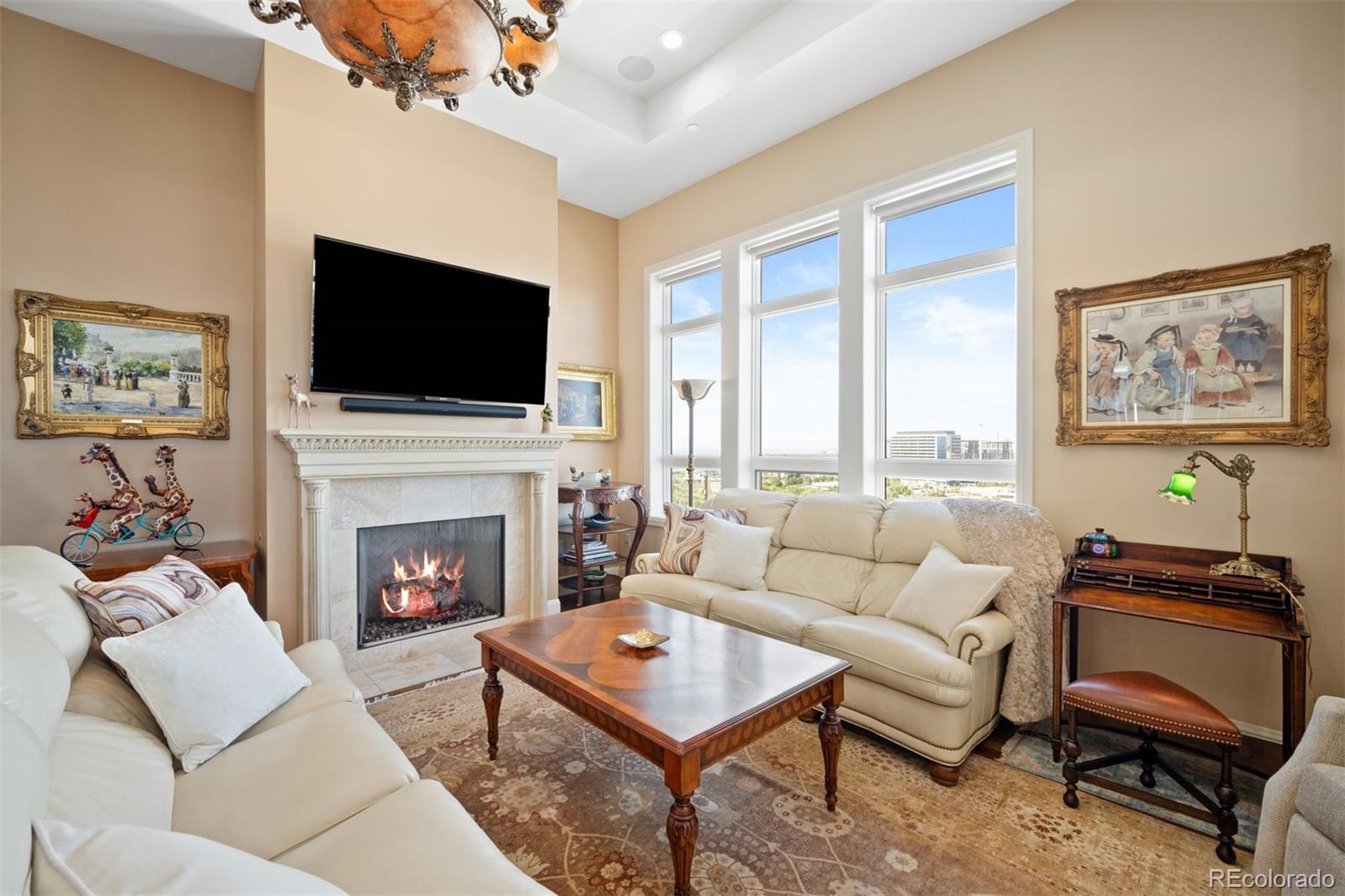 a living room with furniture a flat screen tv and a fireplace