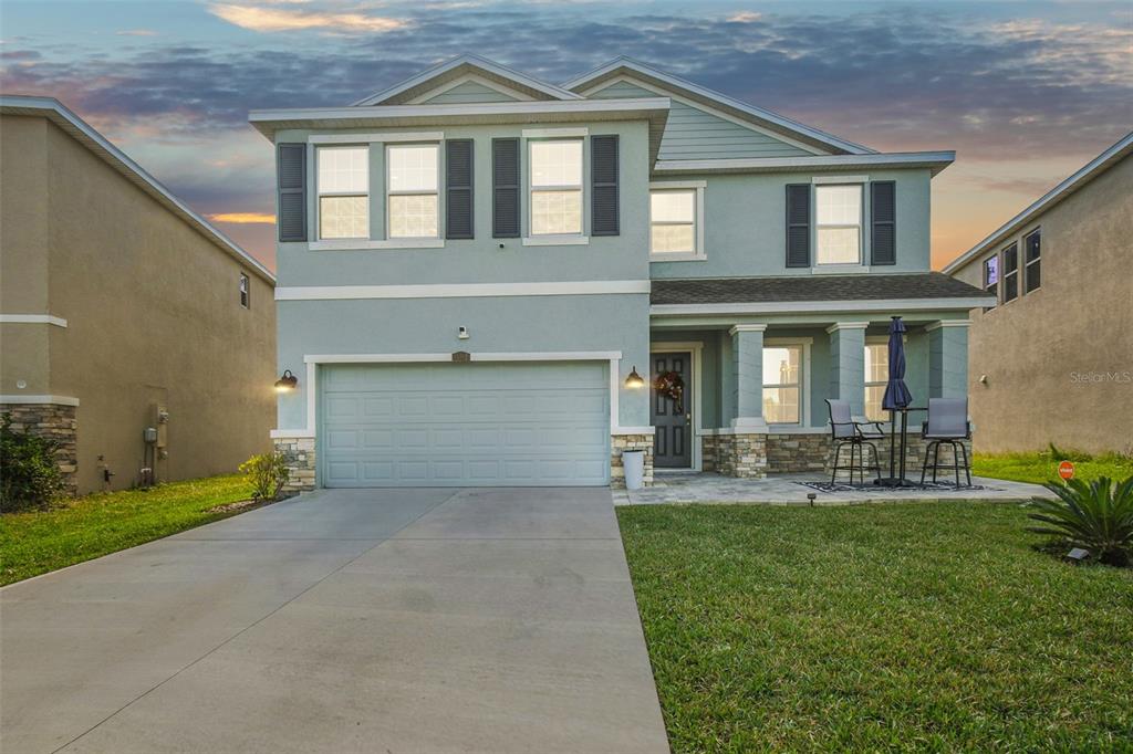 a front view of a house with a yard and patio