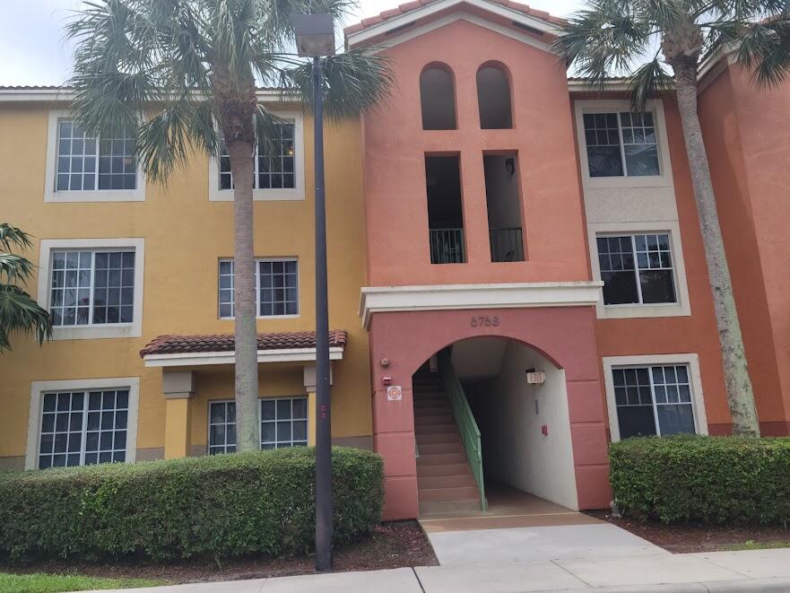 a front view of a building with a garden