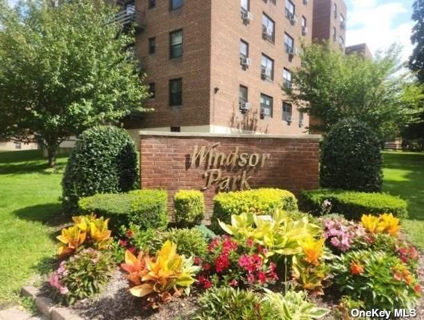 a view of a building with a yard and flowers in front of it