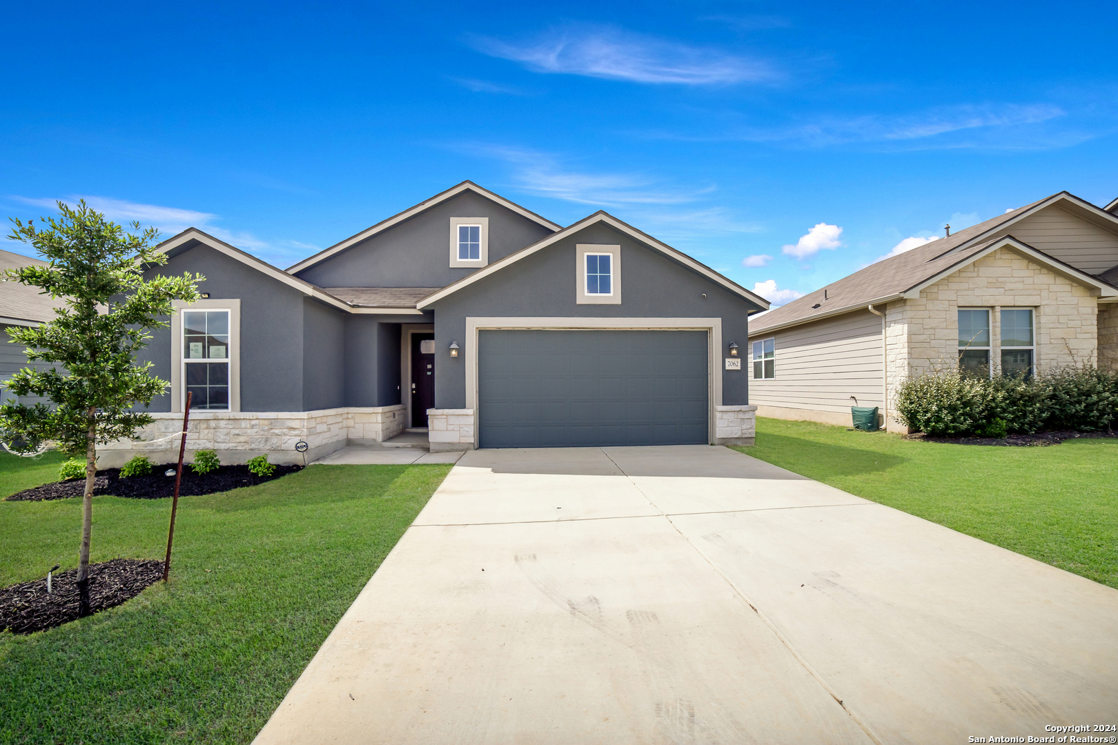 a front view of a house with a yard and garage