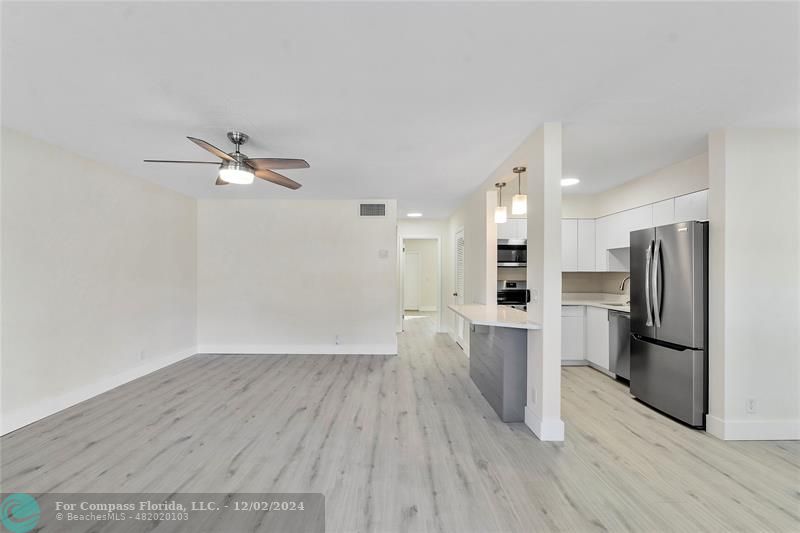 a view of a kitchen with a sink and a refrigerator