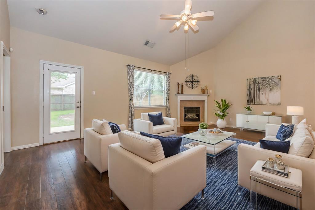 a living room with furniture a fireplace and a window