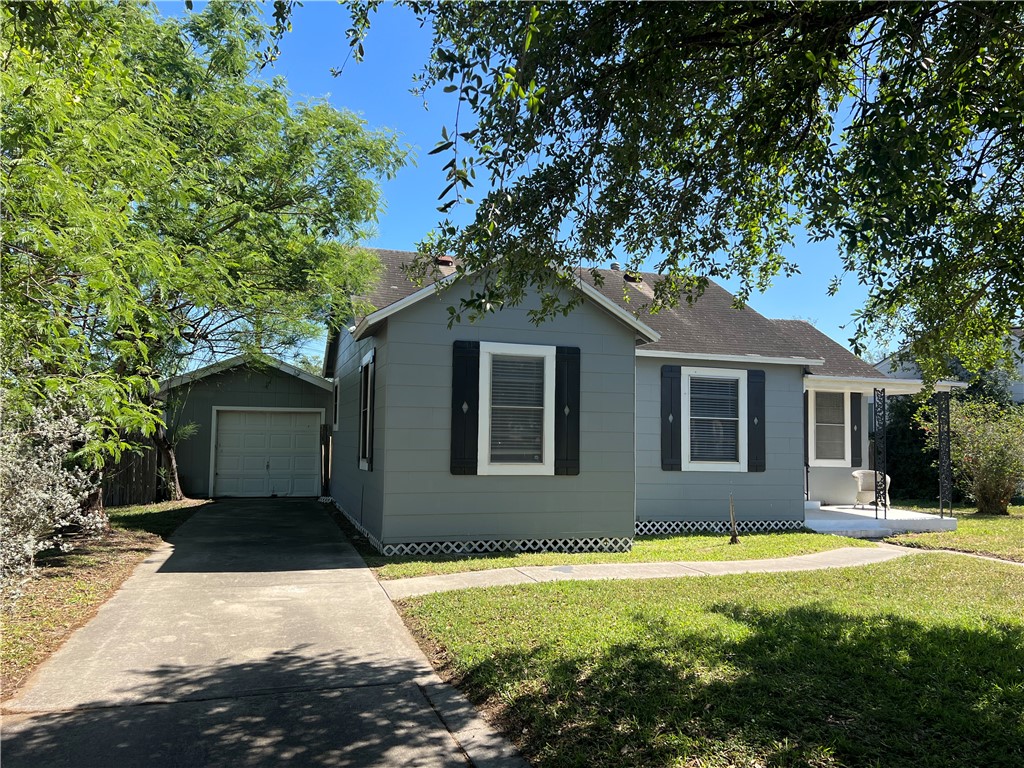 a front view of a house with yard and trees