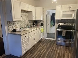 a kitchen with granite countertop a refrigerator stove and oven